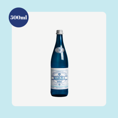 Marzia Still Natural Mineral Water 500ml glass bottle from Tuscany, Italy, displayed on a light blue background with a clean product presentation highlighting the bottle size.
